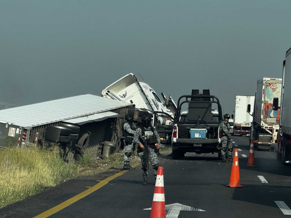 Elementos de la Guardia Nacional resguardan la zona donde un tr\u00e1iler volc\u00f3 sobre el camell\u00f3n central de la carretera federal Celaya\u2013Salamanca.