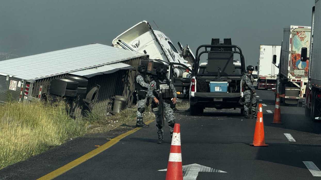 Elementos de la Guardia Nacional resguardan la zona donde un tráiler volcó sobre el camellón central de la carretera federal Celaya–Salamanca.
