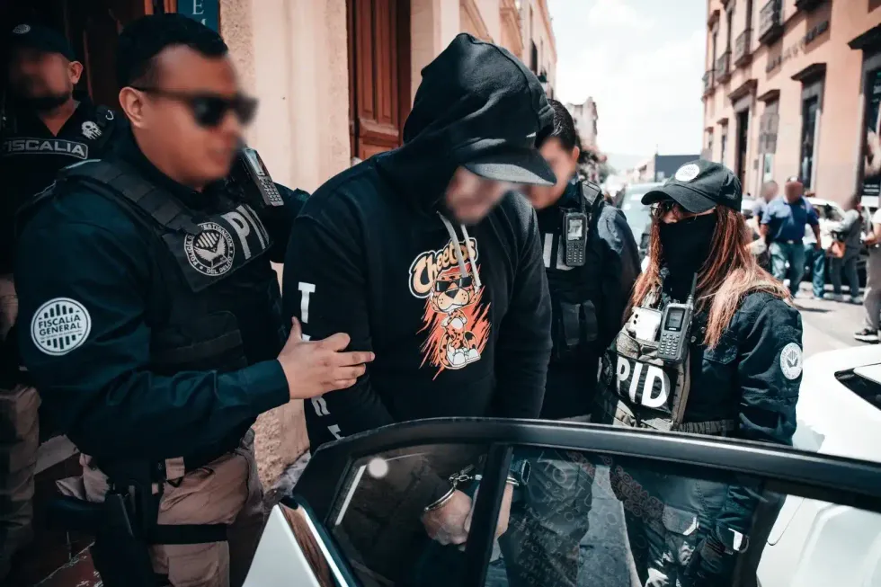 Elementos de la Polic\u00eda de Investigaci\u00f3n del Delito trasladan a una persona detenida durante el operativo en el Centro