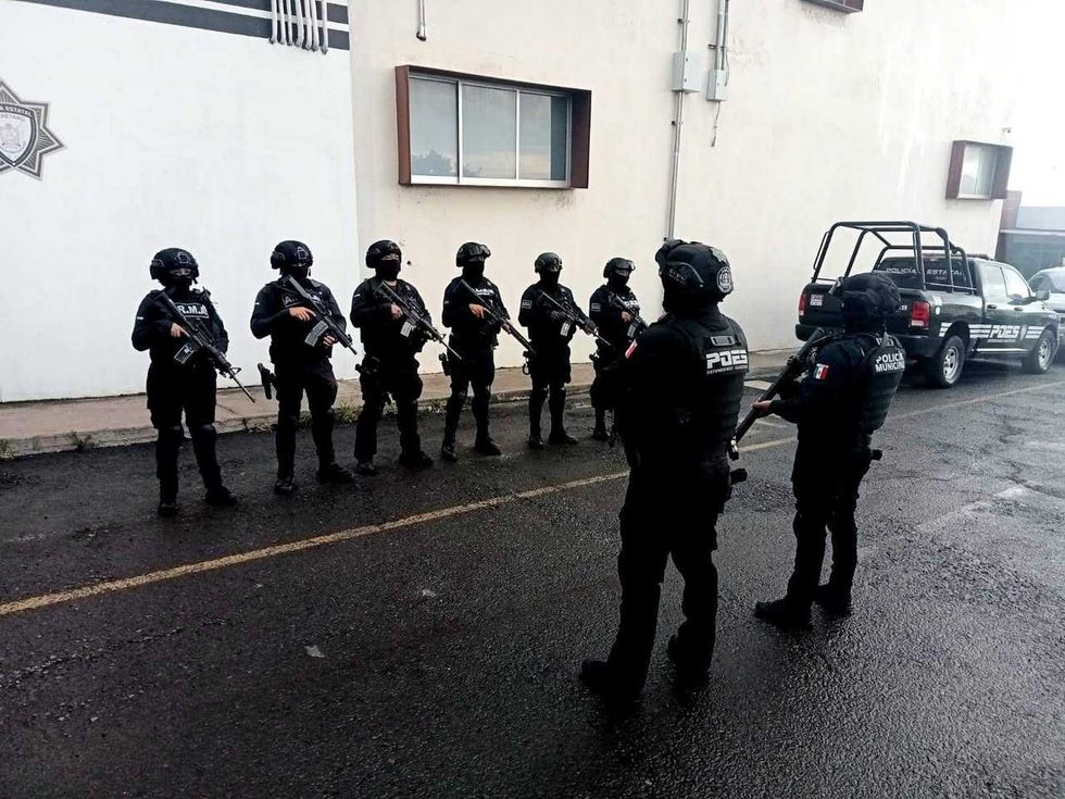 Elementos de la Polic\u00eda Estatal (POES) formados con armamento largo frente a instalaciones policiales antes de un operativo