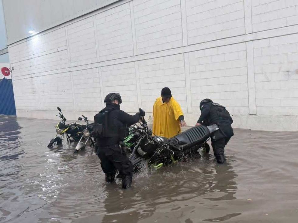 Elementos de la Polic\u00eda Estatal Preventiva auxilian a motociclistas varados por la inundaci\u00f3n en Culiac\u00e1n tras las lluvias del 17 de agosto de 2026.
