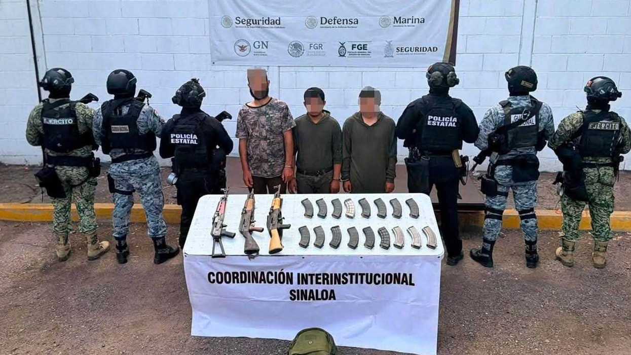 Elementos de seguridad y tres hombres detenidos con el rostro cubierto junto a las armas aseguradas en Mazatlán