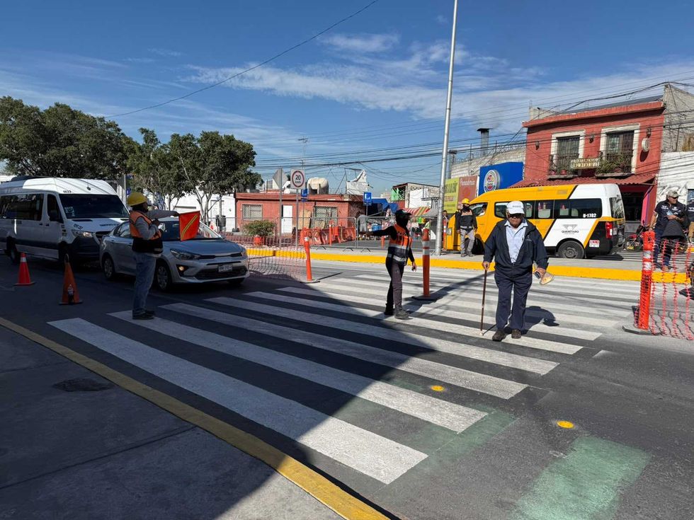 Elementos de tr\u00e1nsito auxilian el paso de peatones y veh\u00edculos en un cruce sobre Corregidora Norte