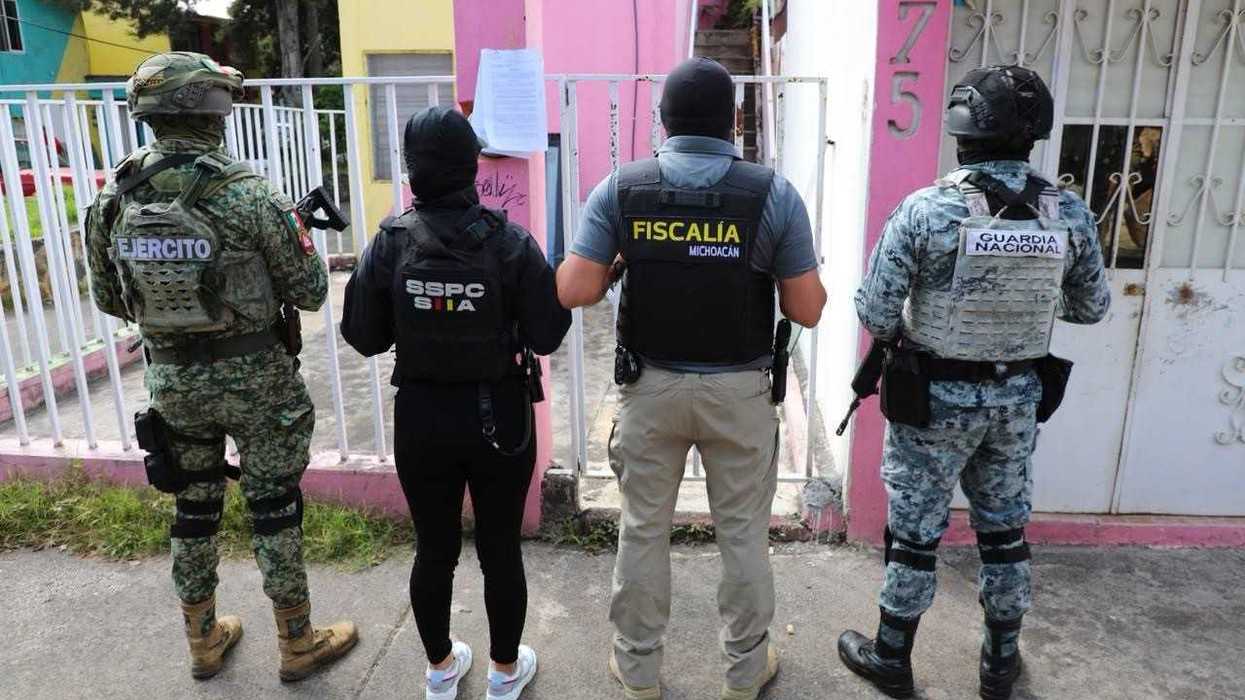 Elementos del Ejército, SSPC, Fiscalía y Guardia Nacional, de espaldas, ante una vivienda con un oficio pegado en la reja