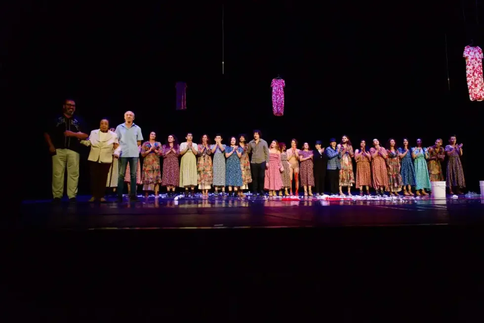 Elenco de bailarines y organizadores recibe el aplauso del p\u00fablico al finalizar una funci\u00f3n.