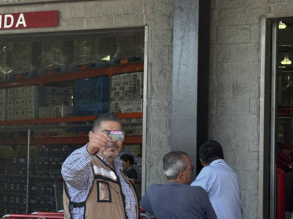 Entrada de una tienda Costco con clientes formados en fila esperando el acceso al establecimiento
