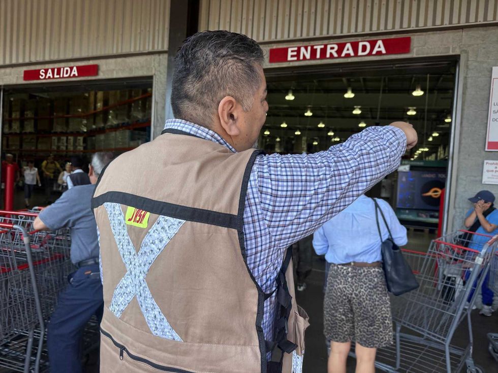 Entrada de una tienda Costco con clientes formados en fila esperando el acceso al establecimiento