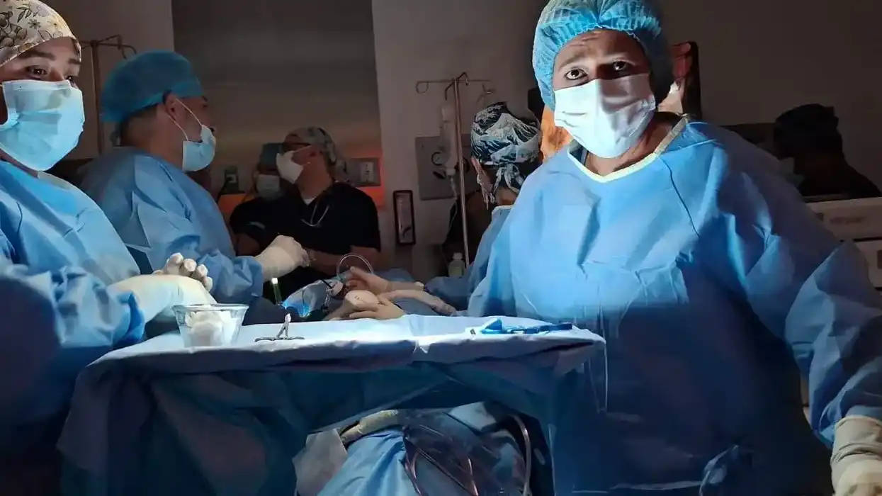 Equipo médico multidisciplinario con batas quirúrgicas azules y cubrebocas trabaja en sala de operaciones durante el primer trasplante cruzado de riñón en Querétaro