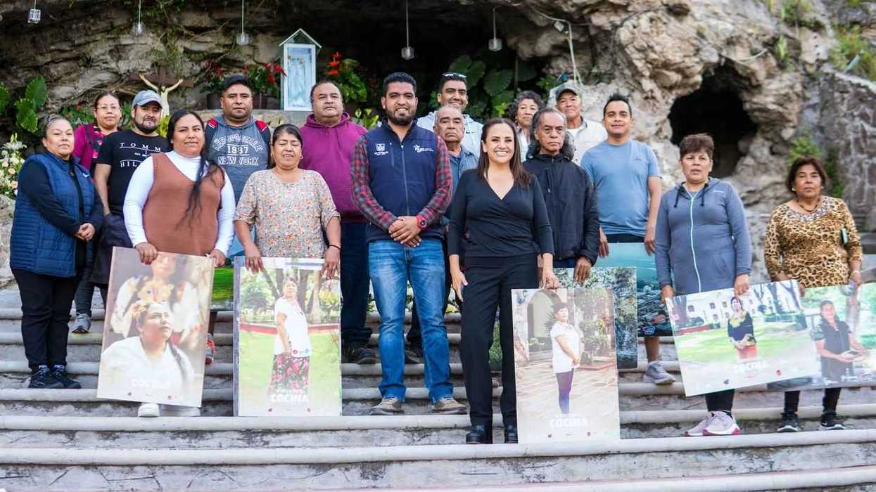 Escalinatas de la gruta de la Virgen de Laguna de Lourdes, en San Juan del Río, donde un grupo de personas posa con carteles.