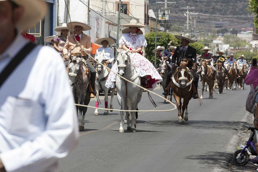 Escaramuzas a caballo con vestido tradicional recorren las calles de San Juan del R\u00edo en el arranque de la feria patronal.