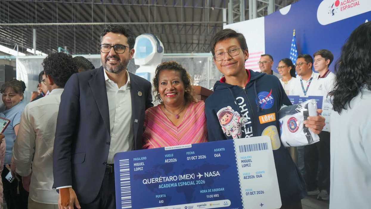 Estudiante de Academia Espacial con boleto simbólico Querétaro-NASA junto a dos adultos en el abanderamiento de becarios