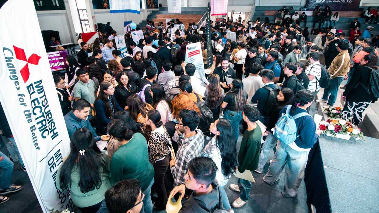 Estudiantes conversan con un representante de empresa en la feria de estadías de la UT San Juan, en San Juan del Río