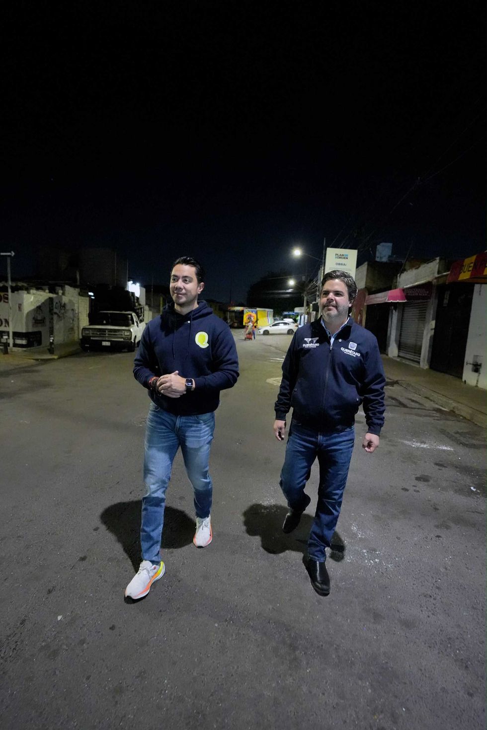Felifer Mac\u00edas y Armando Presa Ortega caminan por calle de Quer\u00e9taro durante recorrido nocturno de supervisi\u00f3n de limpieza urbana