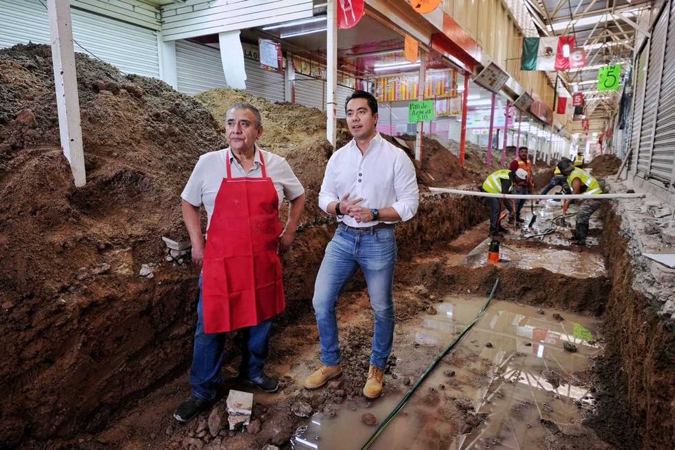 Felifer Mac\u00edas y un comerciante junto a una zanja de excavaci\u00f3n en un pasillo del mercado Escobedo