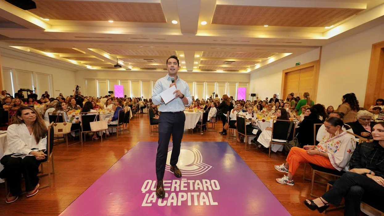 Felifer Macías, presidente municipal de Querétaro, habla con micrófono en el escenario "Querétaro La Capital" ante mujeres líderes de la capital.