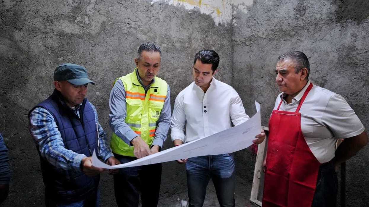 Felifer Macías revisa planos de la obra junto a personal y un comerciante en el mercado Escobedo