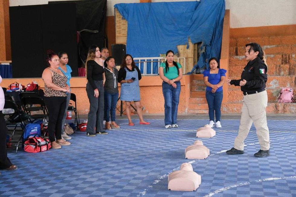 Fila de mujeres participa en din\u00e1mica grupal durante taller de primeros auxilios en gimnasio de Quer\u00e9taro
