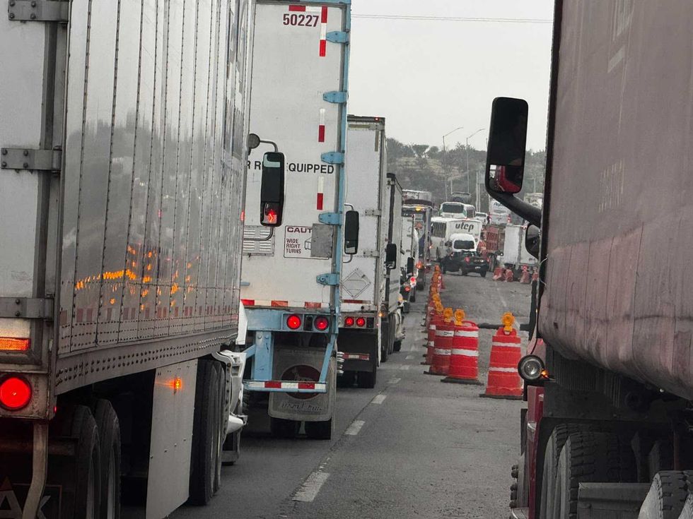 Fila de tractocamiones detenidos entre trafitambos de obra en la autopista M\u00e9xico-Quer\u00e9taro, a la altura de Palmillas.