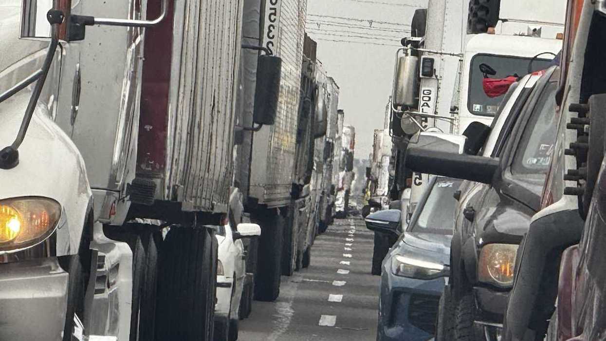 Filas de camiones de carga y vehículos circulan por la autopista México-Querétaro en medio de congestionamiento vial.