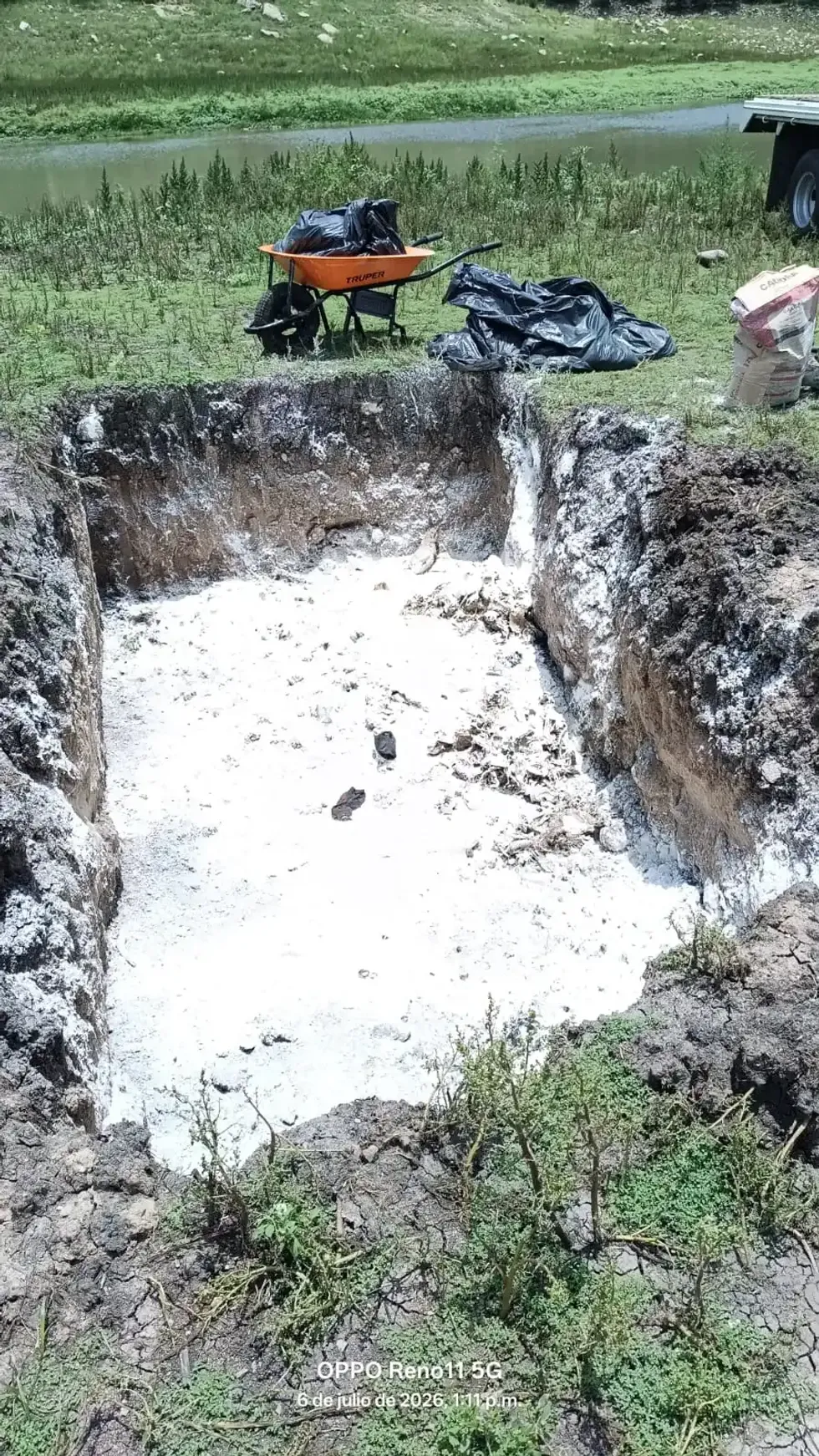 Fosa cubierta con cal, excavada a un costado de la presa El Bat\u00e1n para la disposici\u00f3n del material recolectado.