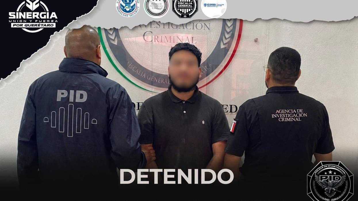 Fotografía difundida por la Fiscalía de Querétaro que muestra al imputado por feminicidio, con rostro difuminado, custodiado por dos agentes de la Agencia de Investigación Criminal, con logotipos de las dependencias participantes en el operativo binacional