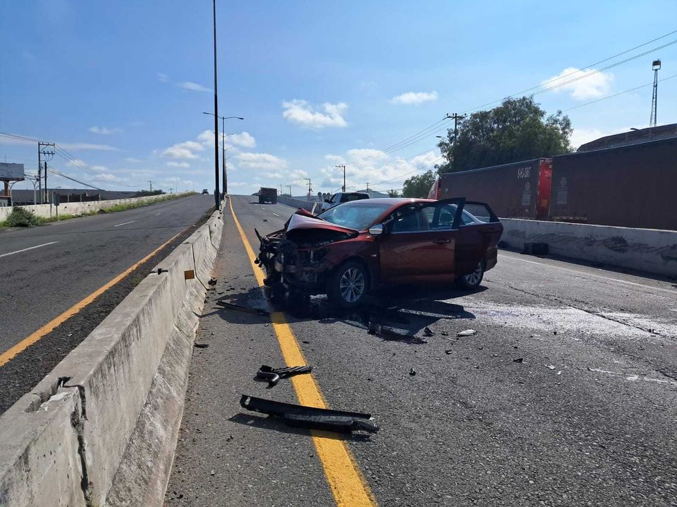 Frente destrozado de Chevrolet Onix rojo sobre carretera San Juan del R\u00edo-Xilitla con escombros en el carril
