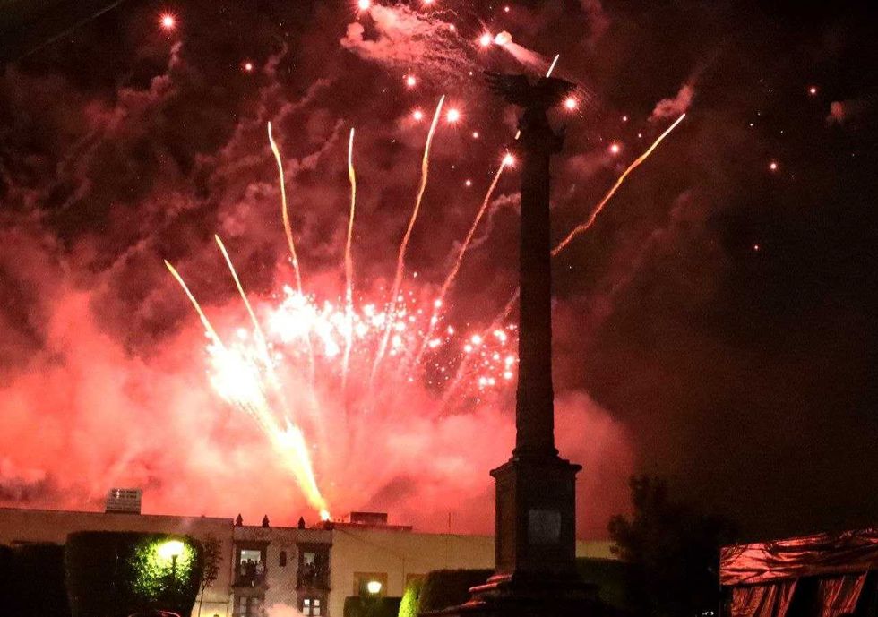Fuegos artificiales de tonos rojos estallan sobre el monumento del \u00c1guila en San Juan del R\u00edo.