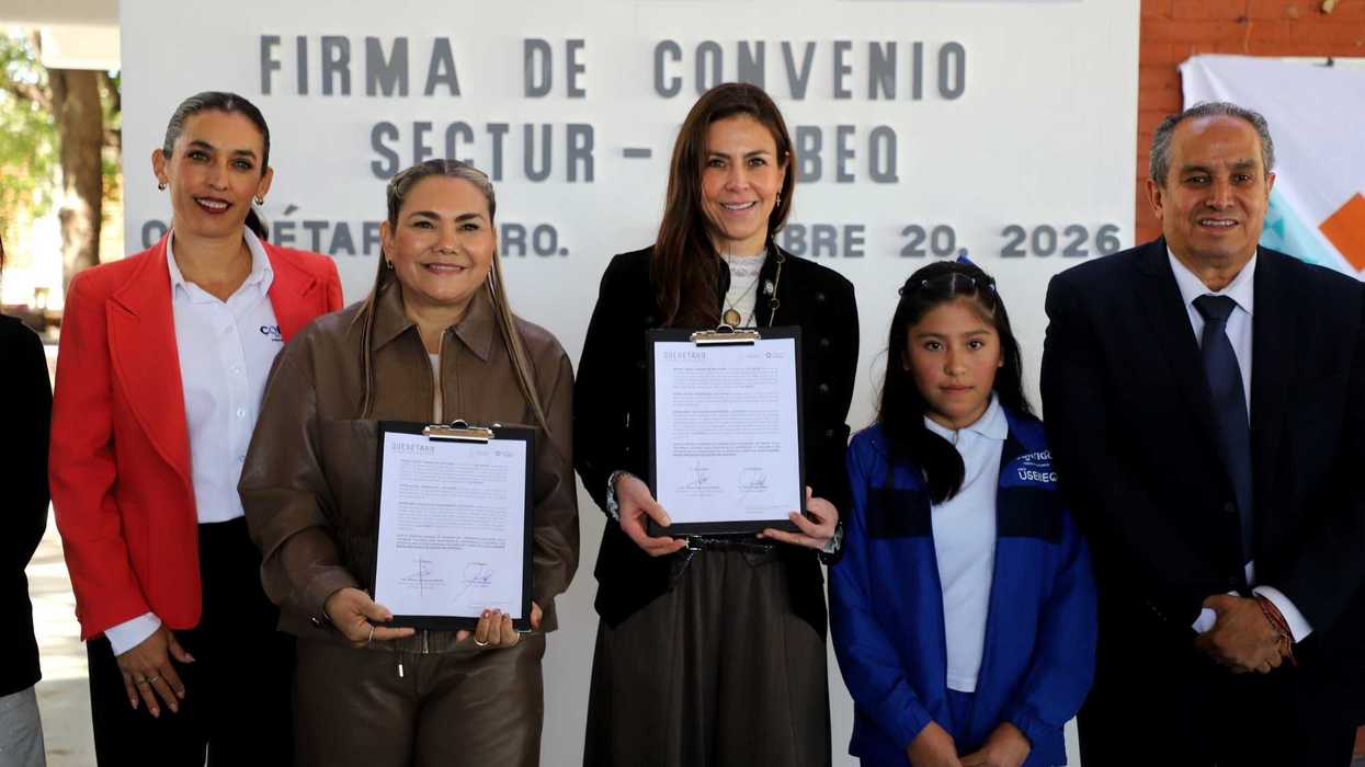 Funcionarias de SECTUR y USEBEQ muestran el convenio firmado junto a una alumna, frente a un letrero de Firma de Convenio SECTUR-USEBEQ