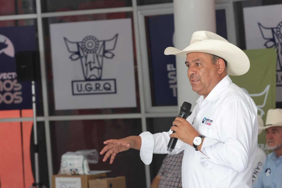 Funcionario estatal con sombrero sostiene un micr\u00f3fono durante la entrega de kits para la atenci\u00f3n del gusano barrenador.