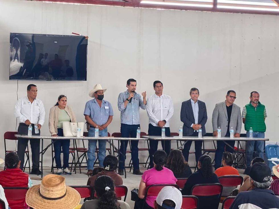 Funcionario habla con micr\u00f3fono ante los asistentes durante la entrega de la Casa Ejidal de La Tinaja