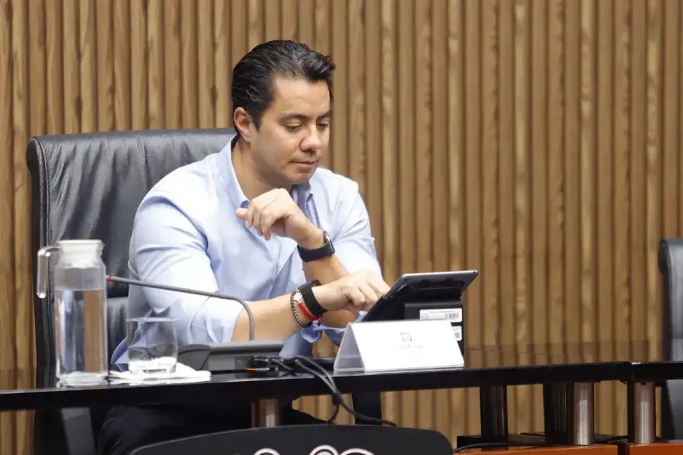 Funcionario municipal revisa documentos en tableta durante sesi\u00f3n de Cabildo