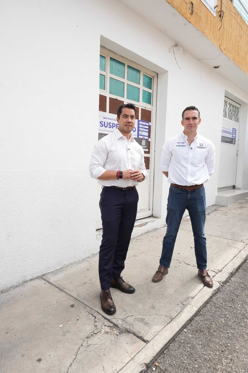 Funcionarios municipales frente al sello de clausura de empresa inmobiliaria en Quer\u00e9taro
