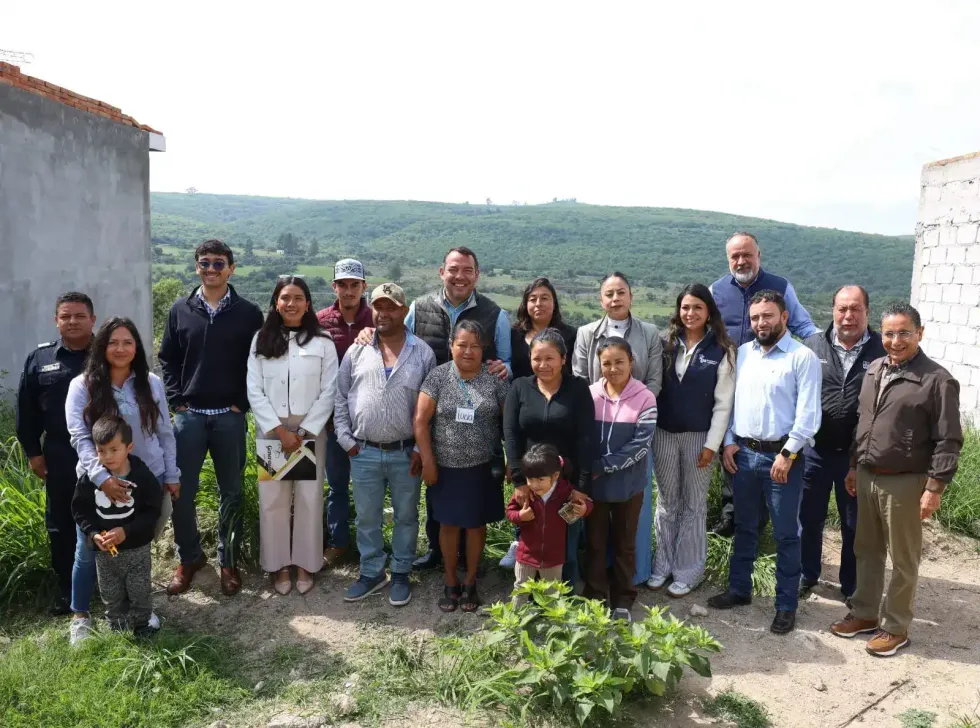 Funcionarios municipales y vecinos de Soledad del R\u00edo posan frente a construcci\u00f3n con cerros al fondo