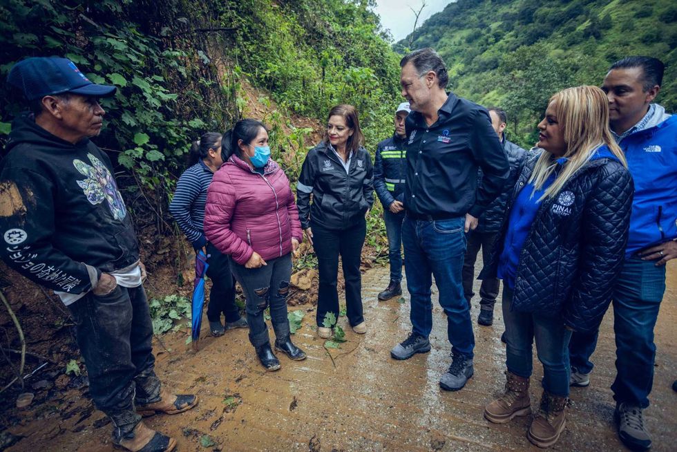 Funcionarios y vecinos recorren el camino de El Ranchito, en Pinal de Amoles, junto a la ladera del deslave