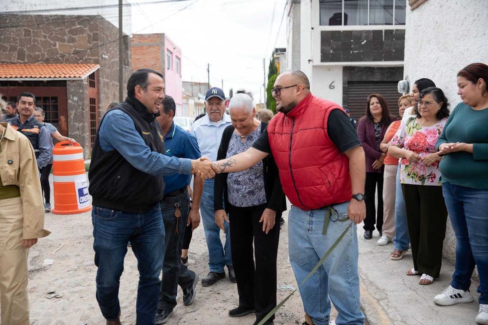 Funcionarios y vecinos reunidos en calle de tierra de colonia Indeco durante arranque de obra