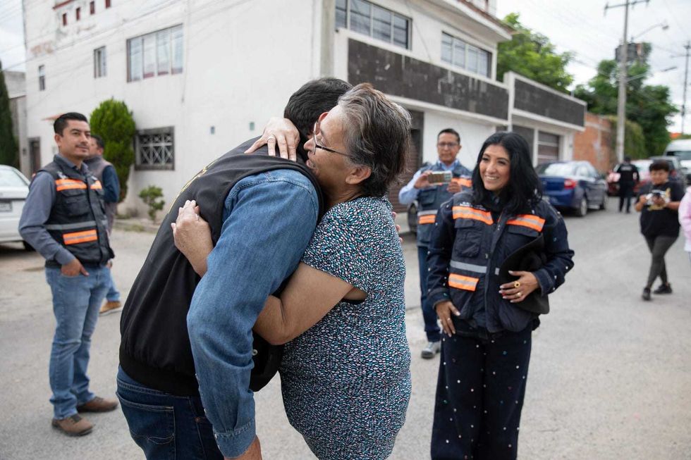 Funcionarios y vecinos reunidos en calle de tierra de colonia Indeco durante arranque de obra