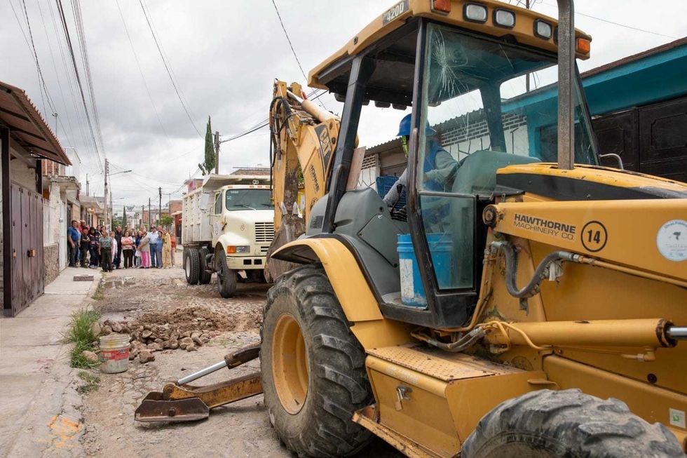 Funcionarios y vecinos reunidos en calle de tierra de colonia Indeco durante arranque de obra