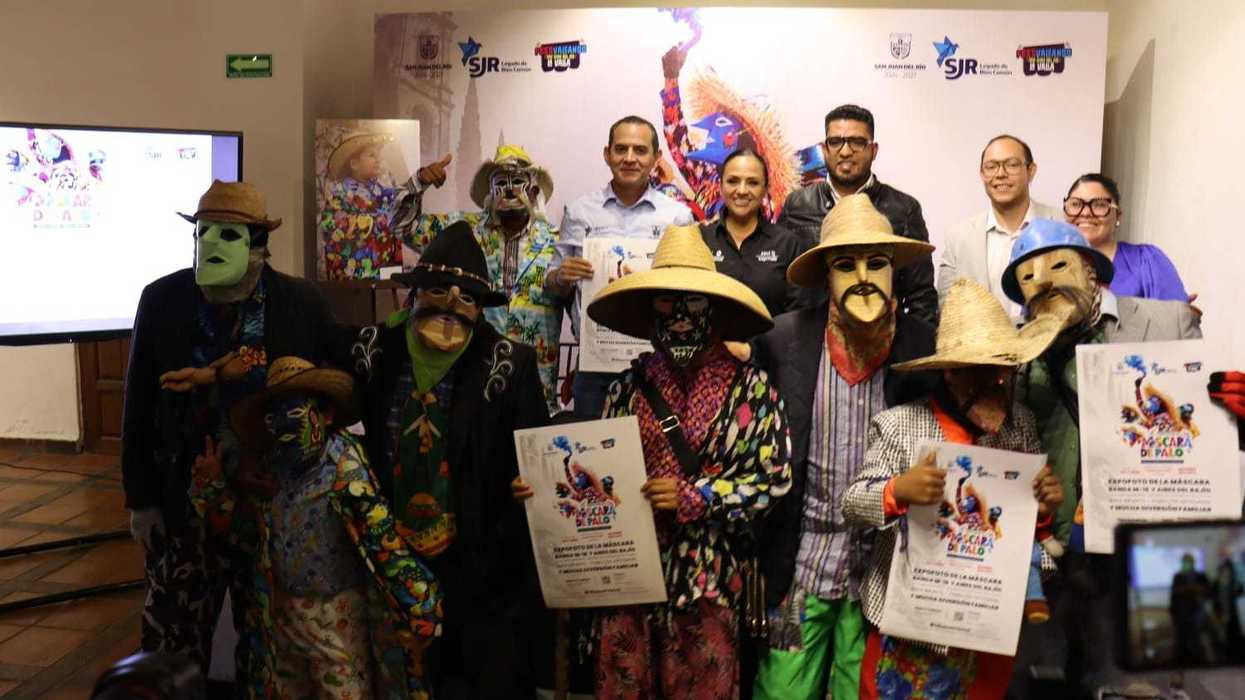 Funcionarios y xhitases con carteles en la presentación del tercer Festival de la Máscara de Palo de La Valla