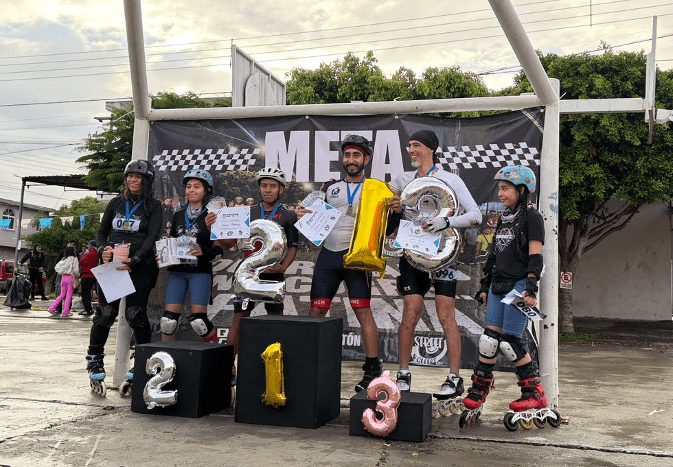 Ganadores del Quer\u00e9taro Marat\u00f3n Roller 2026 posan en el podio frente a la manta de meta