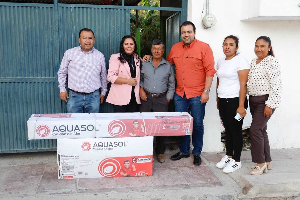 Gaspar Trueba Moncada junto a una vecina beneficiaria frente a su vivienda en Viborillas