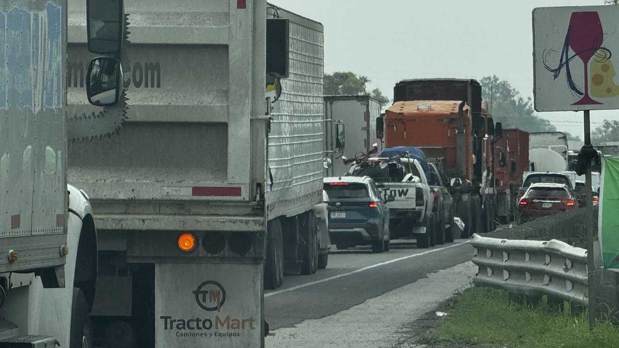 Grúa de arrastre y fila de tractocamiones detenidos en la autopista México-Querétaro durante el embotellamiento de 25 kilómetros registrado en el tramo de Palmillas, agosto de 2026.