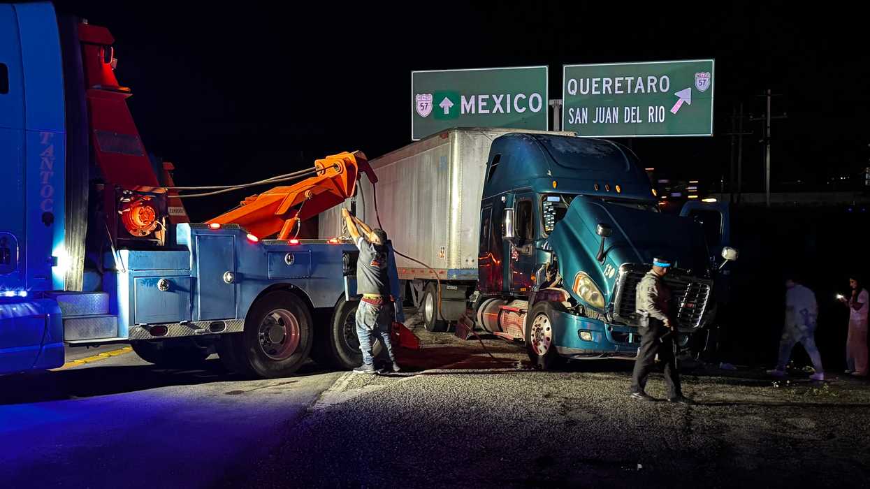 Grúa realiza maniobras para retirar un tráiler volcado en el distribuidor vial de Palmillas, en San Juan del Río.