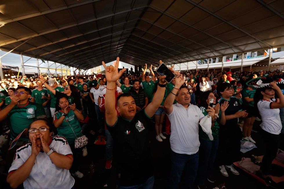 Grupo de aficionados con los brazos en alto celebra en el M\u00e9xicQ Zona Fest de Quer\u00e9taro