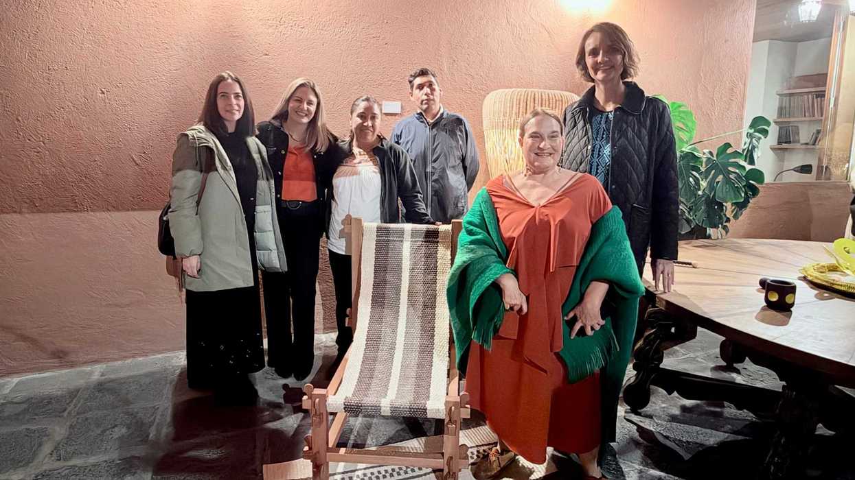Grupo de asistentes posa de noche frente a un muro con vegetación, en actividades de Design Week México 2026