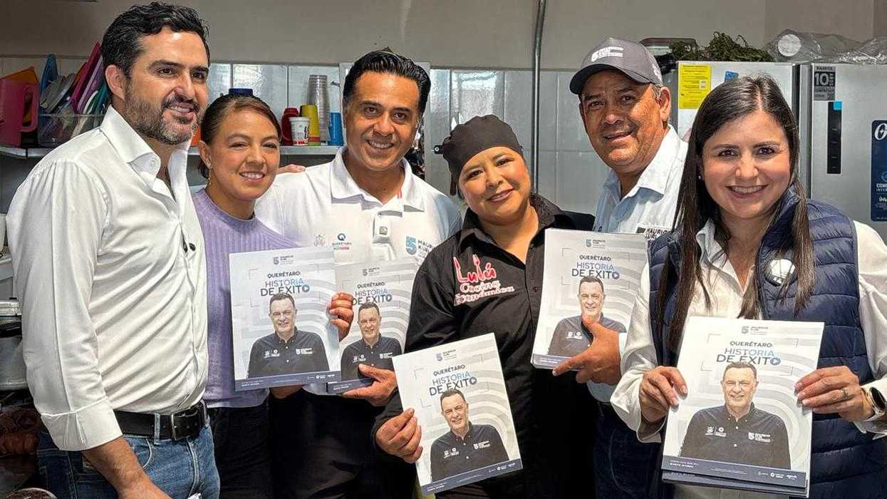 Grupo de funcionarios y comerciantes muestra ejemplares del folleto Querétaro Historia de Éxito en una cocina económica de Amealco de Bonfil.