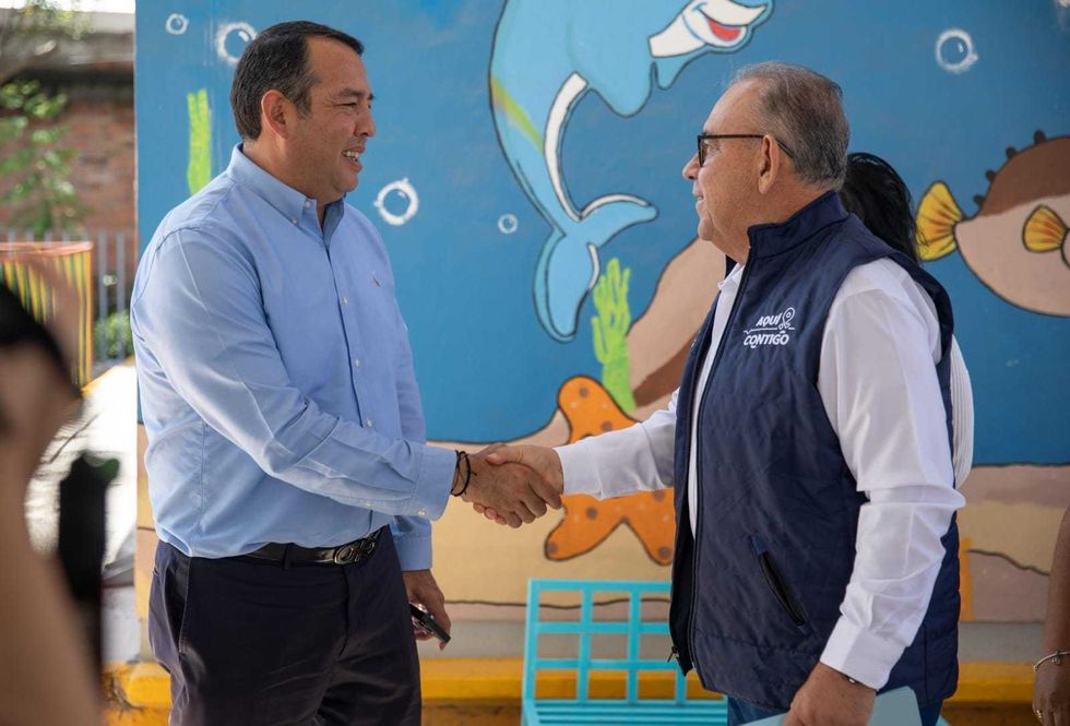 Grupo de funcionarios y personal educativo en el patio de una escuela de San Juan del R\u00edo.