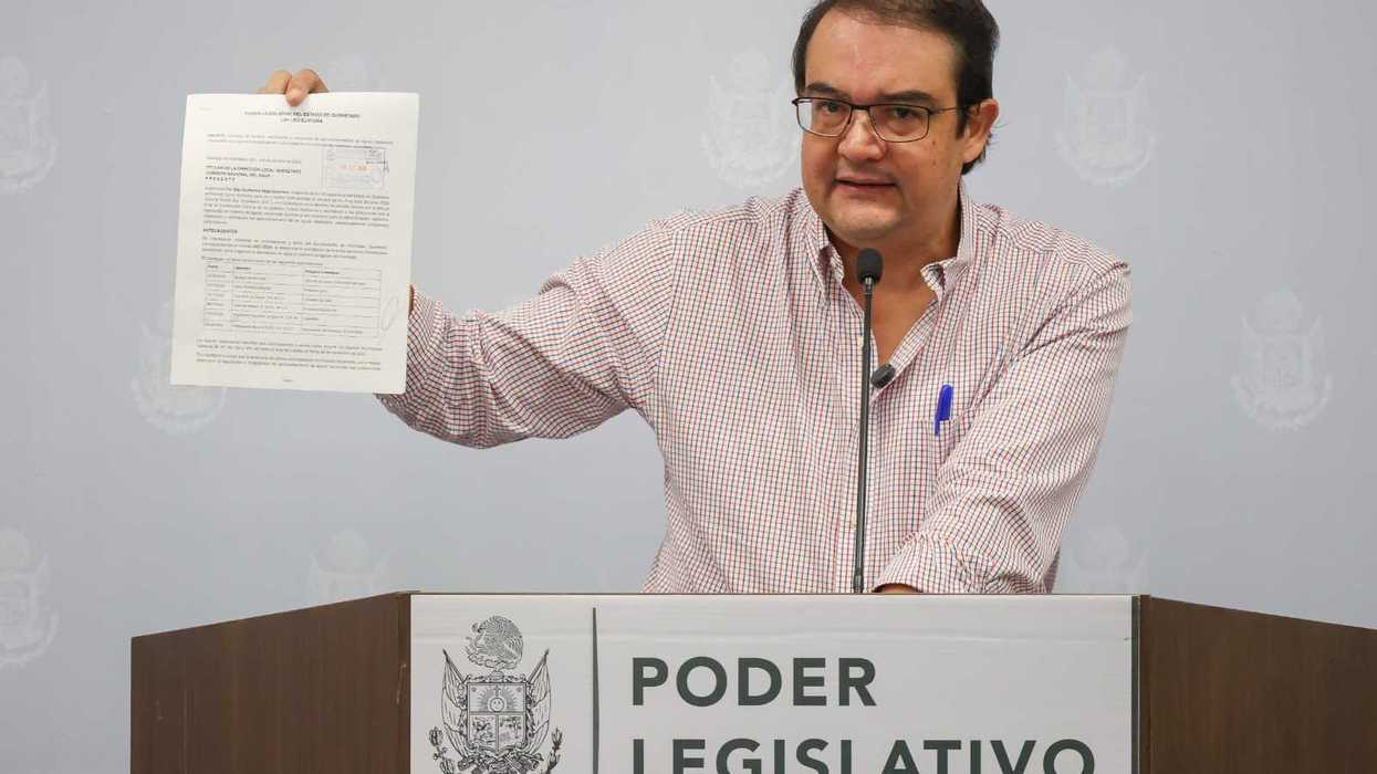 Guillermo Vega Guerrero habla en el podio del Poder Legislativo de Querétaro junto a una pantalla con una infografía.