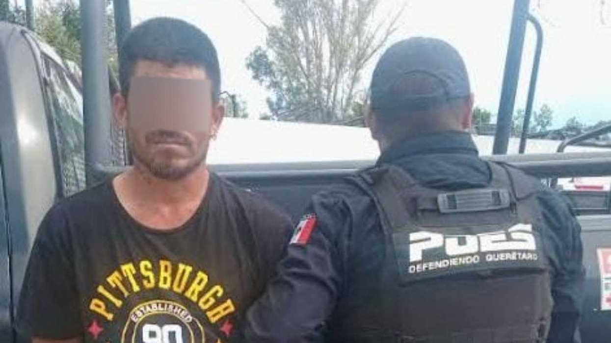 Hombre con las manos esposadas y el rostro cubierto por edición, custodiado por un policía estatal con chaleco táctico con la leyenda "POES, Defendiendo Querétaro", junto a una patrulla, durante un operativo por abigeato en San Fandila, Pedro Escobedo.