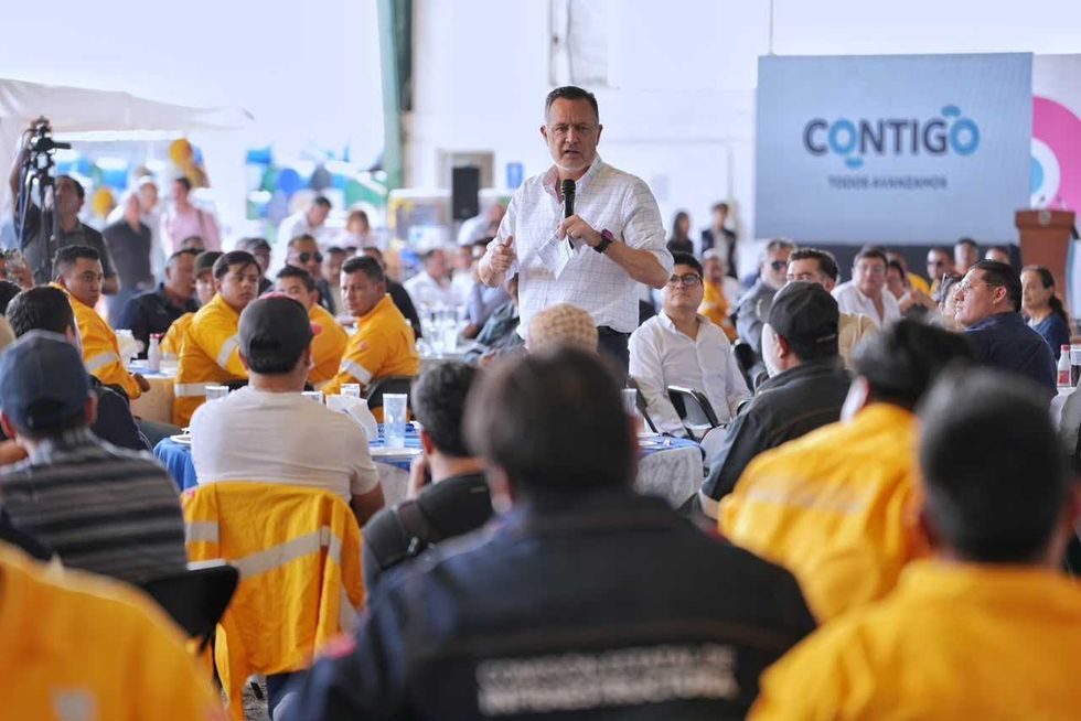 Hombre con micr\u00f3fono se dirige a trabajadores con chalecos amarillos en el festejo del D\u00eda del Caminero de la CEI
