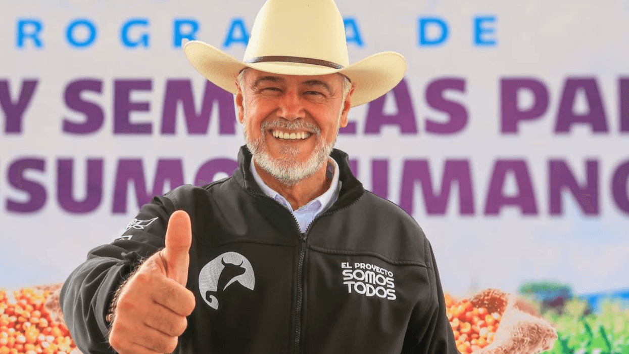 Hombre con sombrero vaquero levanta el pulgar ante costales de grano; aspirante del PAN a diputación federal en Querétaro